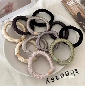 Detail showing various silk texture scrunchies with satin finish and elegant Morandi colors