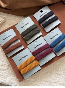 Close-up of knit fabric hair clips in six colors including black and deep purple