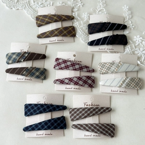 Detail showing various plaid and houndstooth fabric hair clips on fashion display cards