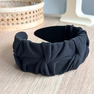 Detail of black pleated fabric headband showing the soft texture and elegant folds