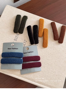 Detailed view of six colorful twill fabric hair clips with a soft knitted texture