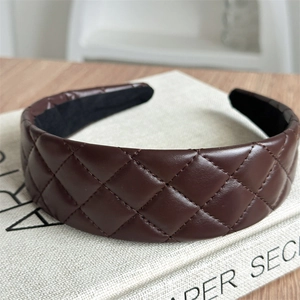 Close-up of brown quilted leather headband featuring vintage French diamond patterns