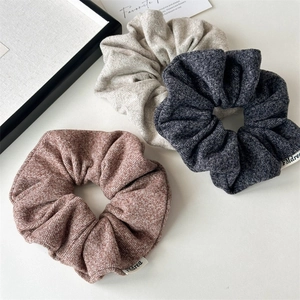 Lot de trois chouchous en maille tricotée de couleurs rouille, beige et gris foncé