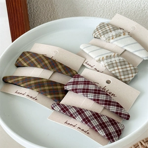 Detailed macro view of checkered fabric BB hair clips in green, red and grey textures