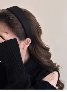 Dettaglio del cerchietto in velluto nero su modella che mostra la texture e lo stile
