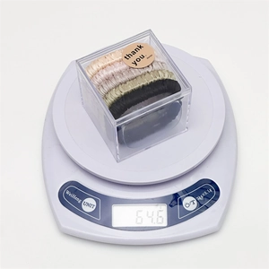 Detailed view of 5-pack satin silk scrunchies set in a gift box on a digital scale