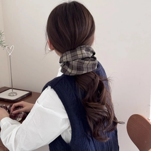Detailed view of a vintage plaid fabric hair scrunchie styled on a low ponytail