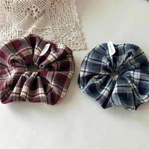 Detailed close-up of handmade vintage plaid scrunchies in dark red and navy blue fabric