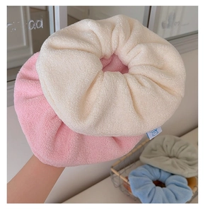 Macro detail of plush towel fabric scrunchies in soft beige pink and blue tones