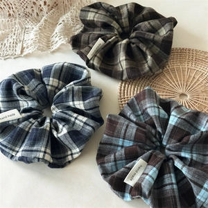 Detailed view of three handmade retro plaid scrunchies in dark brown and navy cotton