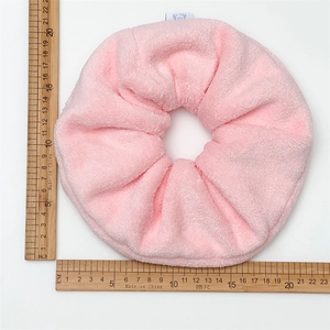 Close-up of oversized pink plush scrunchie showing 16-18cm diameter measurement
