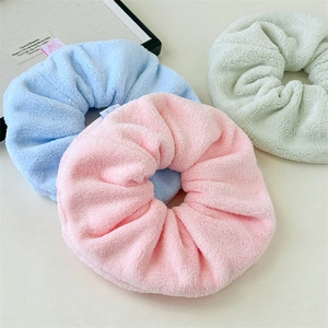 Detailed texture of plush towel fabric scrunchies in pastel blue pink and mint green colors