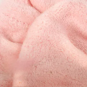 Macro close-up of thick pink coral fleece fabric showing soft absorbent microfiber texture