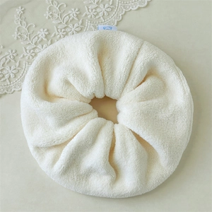 Close-up of fluffy beige microfiber scrunchie with cute blue cartoon bear tag