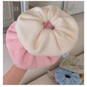 Oversized plush hair scrunchies in pastel colors made of soft coral fleece material