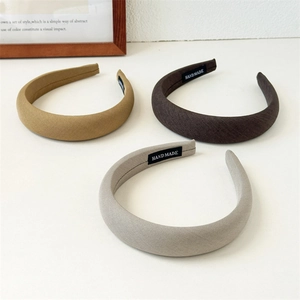 Detail of three thick padded headbands with handmade woven labels on white background