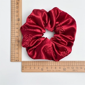 Luxurious red satin scrunchie with rose embossing floral pattern measuring 11cm diameter