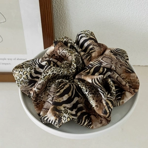 Detail showing the leopard, zebra, and snake print patterns on large satin scrunchies