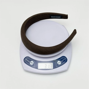 Brown fabric padded headband with handmade label shown on a scale weighing 31.3 grams