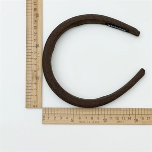 Detail of dark brown padded headband with Handmade label showing 12.5cm size scale