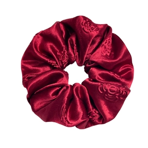 Luxurious burgundy satin scrunchie with embossed rose patterns and elegant silk texture