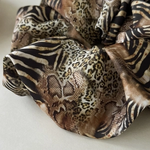 Close-up of leopard and zebra print satin scrunchie showing silky texture and ruffles