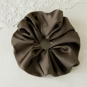 Detailed view of large brown satin leopard print scrunchie with silky smooth texture