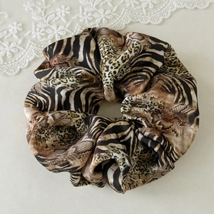 Detailed shot of large satin leopard and zebra print scrunchie with soft fabric pleats