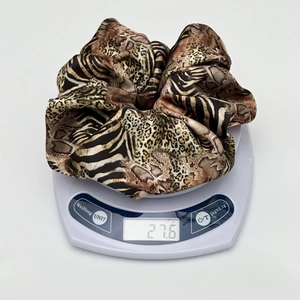 Weight measurement of large leopard print satin scrunchie on a white digital scale