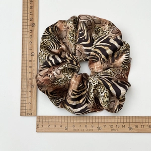 Detailed view of large leopard and zebra print satin scrunchie measuring 12cm