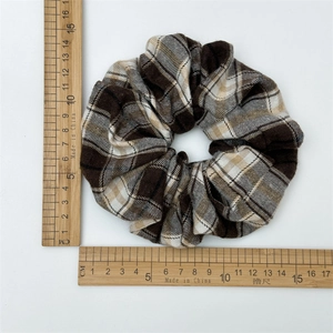 Chouchou à carreaux marron classique avec mesure de 12 cm de diamètre sur fond blanc