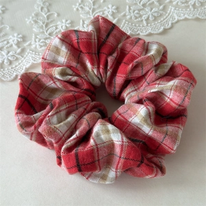 Gros plan d'un chouchou à carreaux rouges et blancs avec une texture en coton doux