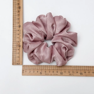 Dusty pink satin scrunchie with 10cm diameter measurement showing elastic silk texture