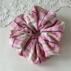 Gros plan sur le chouchou à carreaux roses avec texture douce sur dentelle