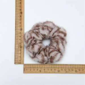 Macro shot of faux fur zebra print hair scrunchie showing 11.5cm diameter on ruler