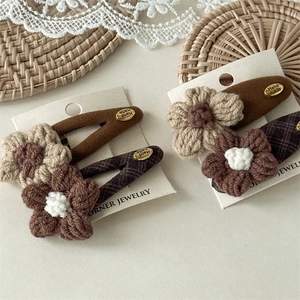 Handmade crochet flower hair clip set in earthy brown tones on branding display card