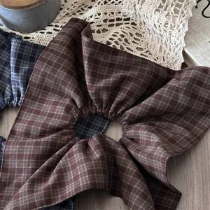Detailed close-up of brown and navy plaid scrunchies with elegant fabric textures