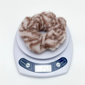 Close-up of zebra pattern plush scrunchie on electronic scale weighing 25.0g
