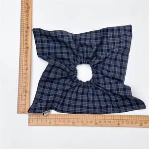 Classic blue and grey plaid fabric hair scrunchie with handmade label on white background
