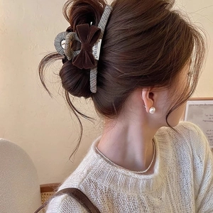 Detail view of large velvet bow hair claw clip in a stylish high bun hairstyle