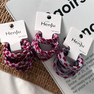 Detailed view of elastic hair bands with plaid and heart patterns on card packaging