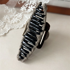 Detail of tweed hair claw clip with a velvet bow and elegant vintage finish