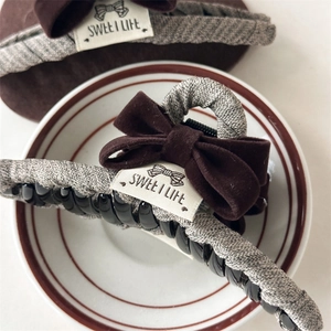 Detail of velvet bow hair claw clip with Sweet Life label and grey textured fabric wrap