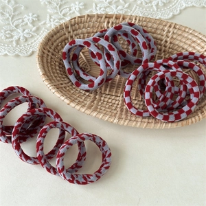 Detail of red and grey knitted elastic hair bands with heart and checkerboard patterns