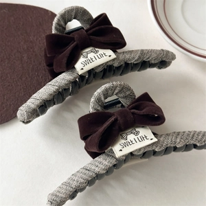 Detail of velvet bow hair claws with Sweet Life labels and tweed fabric wrapping