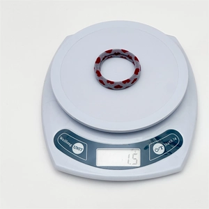 Detail view of a heart pattern hair scrunchie showing the weight on a digital scale