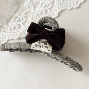 Detailed view of large grey knit claw clip with red velvet bow and Sweet Life label