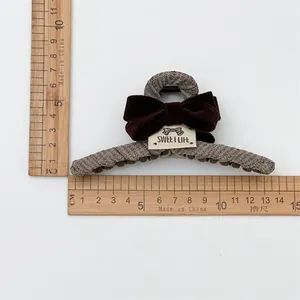 Detail view of 11.5cm tweed hair claw clip with velvet bow and measurement scale