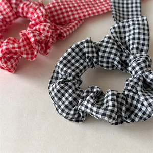 Detail of red and black checkered bow scrunchies with soft cotton fabric texture