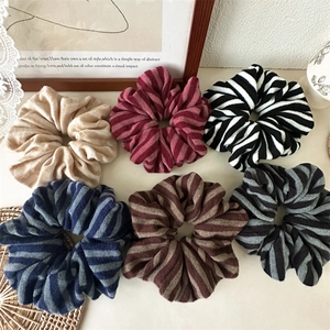 Close-up of a 6-piece set of striped knit scrunchies in various warm autumn colors
